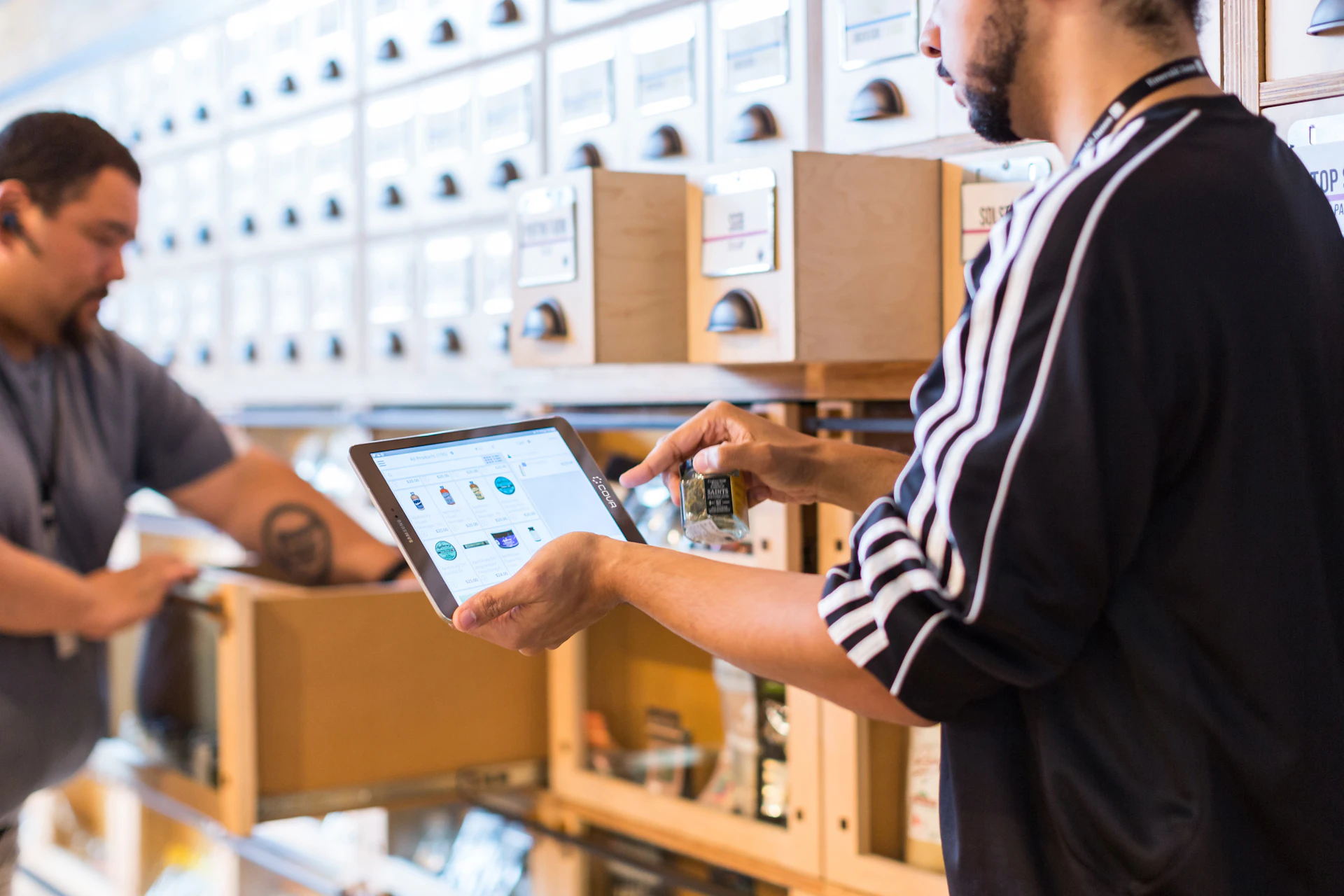 Logistics team coordinating shipments with digital tablets in a bright, uncluttered office space